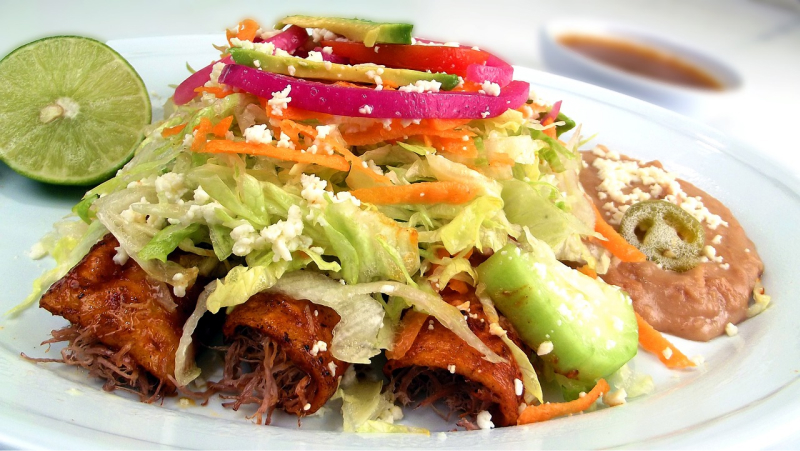 Prim-plan cu o farfurie de enchiladas, mâncare mexicană tradițională